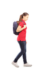 Fototapeta premium Full length portrait of a sad schoolgirl with a bag walking