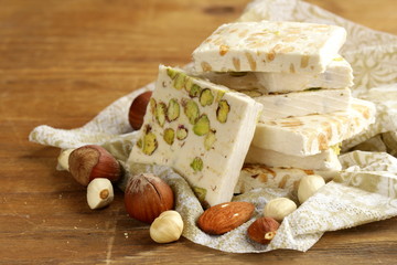 white nougat with different nuts on a wooden table