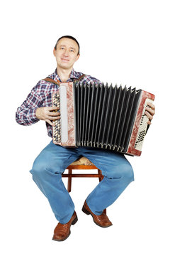 Man with harmonica sits on a chair