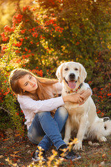 Beautiful woman and her dog posing in autumn park