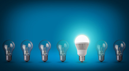 Idea concept on blue background. Row with light bulbs and LED bu