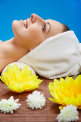 Beautiful young woman lying relaxed in a spa salon
