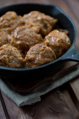 Cast-iron pan with meatballs, close-up, vertical shot