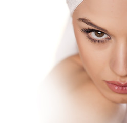 calm beautiful girl with a towel on her head posing on white