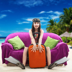 Fototapeta na wymiar Funny girl with her luggage, tropical beach background