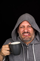 Portrait of disgusted man drinking a cup of coffee