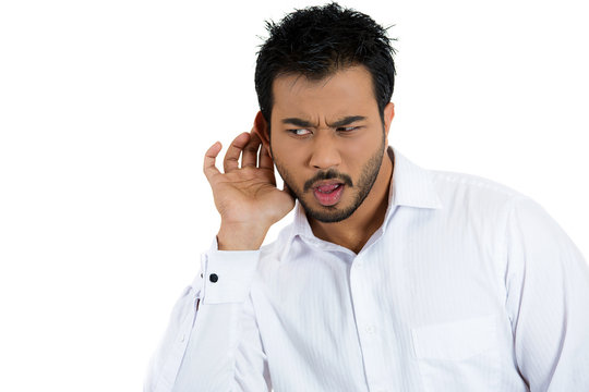 Unhappy, disgusted man listening secretly to a conversation