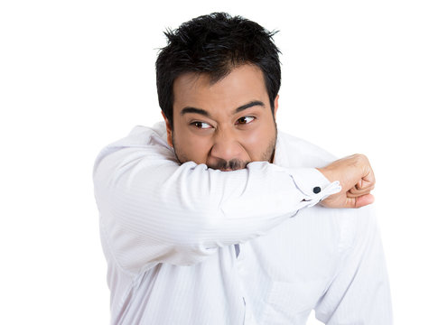 Stressed, upset, crazy looking man biting his arm