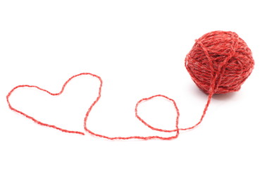 Heart shape and wool ball on white background