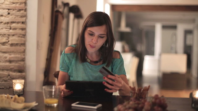 Young woman doing online shopping on tablet at home