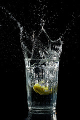 Splash water like vodka in the glass on dark background