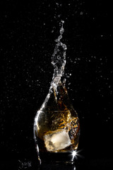 Splash water like whiskey in bottle shape on dark background