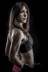 Fototapeta na wymiar Conflict, strong woman athlete with boxing gloves