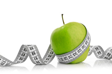 Measuring tape wrapped around a green apple - 59906329