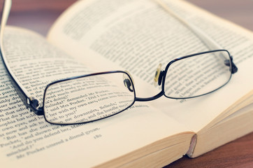 Old glasses and a book on the library desk