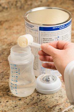 Mother preparing baby formula for infant