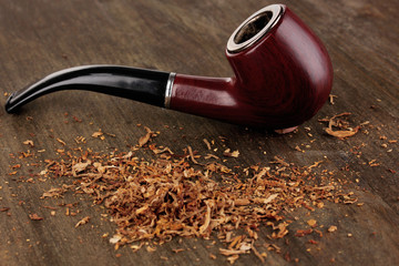 Smoking pipe and tobacco on wooden table close-up