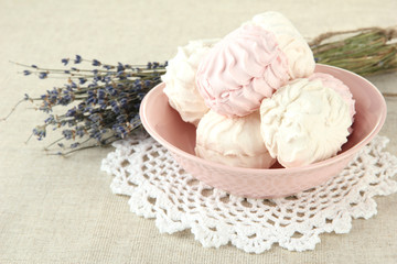 Marshmallows on color plate on light background