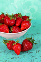 Strawberries in plate on blue background