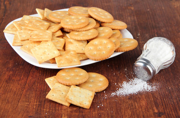 Delicious crackers with salt on wooden background