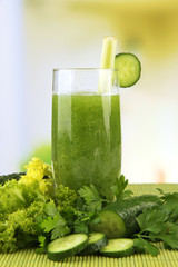 Glass of green vegetable juice and vegetables