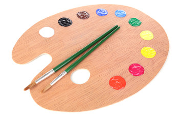 Wooden art palette with paint and brushes isolated on white