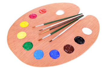 Wooden art palette with paint and brushes isolated on white