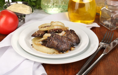 Fried chicken livers on plate on wooden table close-up