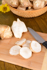 Topinambur roots on cutting board on table close-up