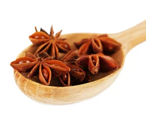 Fotobehang Star anise in wooden spoon, isolated on white © Africa Studio