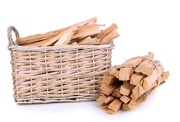 Stack of firewood in wicker basket isolated on white