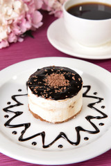 Sweet cake with chocolate on plate on table close-up