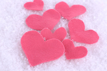 Fototapeta premium Little felt hearts on snowy background