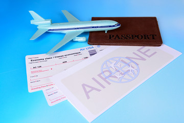 Airline tickets with passport on light blue background