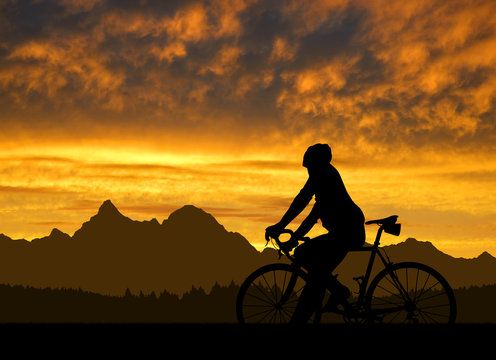 silhouette of the cyclist on road bike at sunset