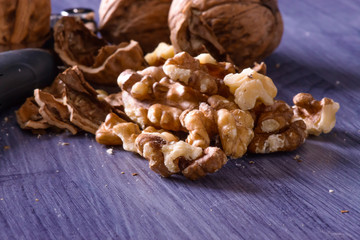 Closeup of cracked walnuts on purple table