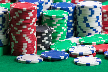 colorful poker chips on a green casino felt