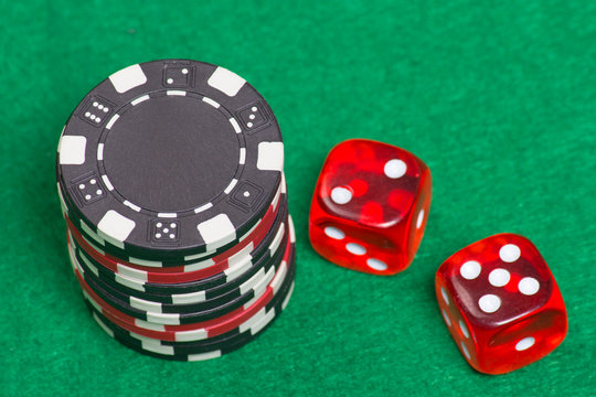 Black And Red Poker Chips And Dice On A Green Felt