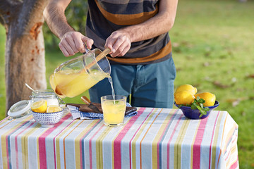 Pouring homemade lemonade in glass