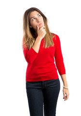 Cute young girl thinking an idea over isolated white background