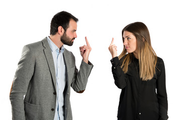 Young businessperson doing the horn sign over white background