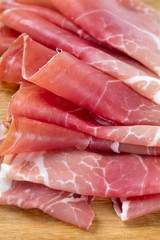 sliced prosciutto on a wooden board
