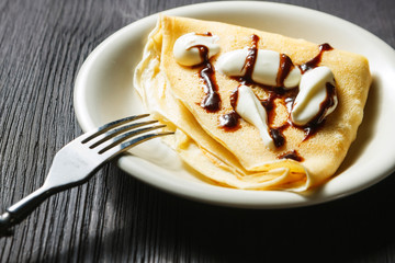 Closeup of chocolate pancakes with whipped cream