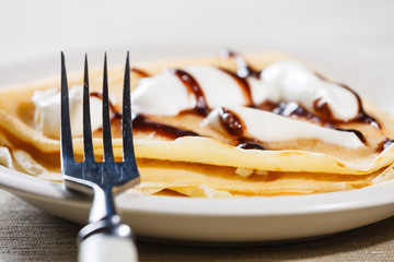 Close up of French style crepe with cream and chocolate sauce