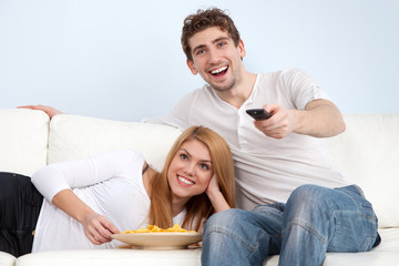 Young couple watching tv at home