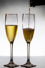 empty glasses of champagne and one being filled 