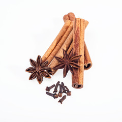 Cinnamon, anise and cloves on white background