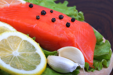 Trout fillet with lemon, garllic and lattuces leaves. Close up