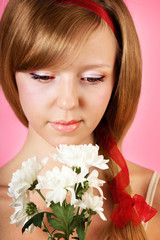 Beautiful woman with white flowers on pink background