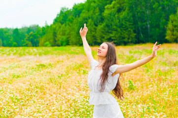 Naklejka na ściany i meble brunette with a flower field with arms outstretched to the sides